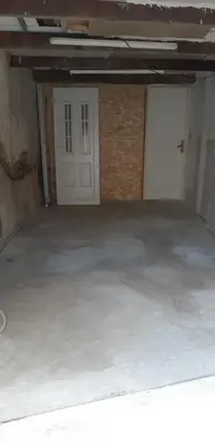 an empty garage with a white door and a doorway at Chez Timmy in Oupia
