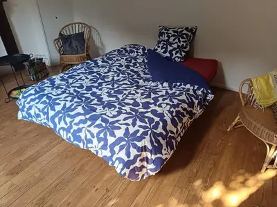 a bedroom with a bed with a blue and white comforter at Chambre et b&b in Miraval-Cabardès