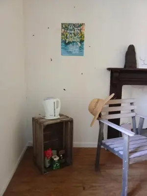 a hat sitting on a wooden table next to a chair at Chambre et b&b in Miraval-Cabardès