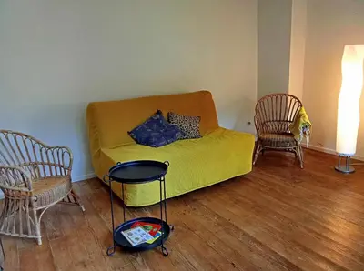 a living room with a yellow couch and two chairs at Chambre et b&b in Miraval-Cabardès