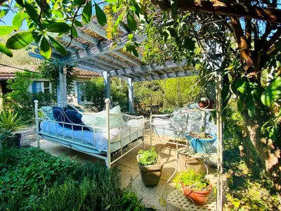 a bed under a pergola in a garden at Peaceful Gite By The Black Mountain in Caunes-Minervois