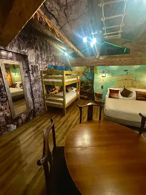 a room with two bunk beds and a wooden table at Studio repaire des pirates du Cloitre in Narbonne