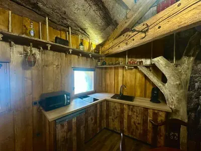 a kitchen with wooden walls and a sink and a window at Studio repaire des pirates du Cloitre in Narbonne