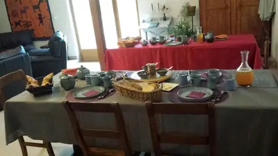 a table with plates and a basket of food on it at Au pied du Figuier in Pauligne