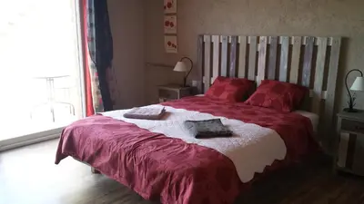 a bedroom with a large bed with red pillows at Au pied du Figuier in Pauligne