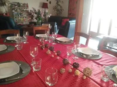 a table with a red table cloth with wine glasses at Au pied du Figuier in Pauligne