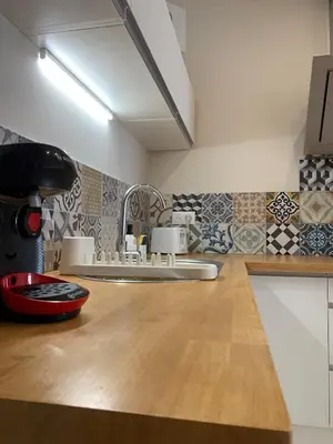 a kitchen with a counter with a sink and tiles at Gili Air, Les Halles et les Grands Buffets in Narbonne