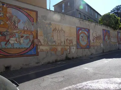a wall with paintings on the side of a street at Chez Jérôme, au pied de la cité médiévale in Carcassonne