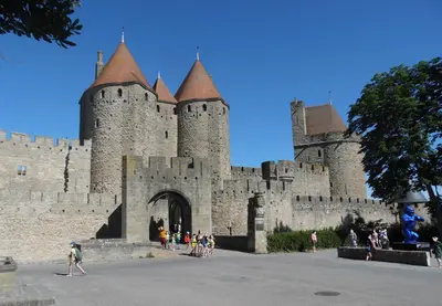 a castle with a bunch of people standing in front of it at Chez Jérôme, au pied de la cité médiévale in Carcassonne