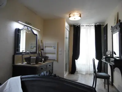 a bedroom with a bed and a sink and a mirror at Chez Jérôme, au pied de la cité médiévale in Carcassonne