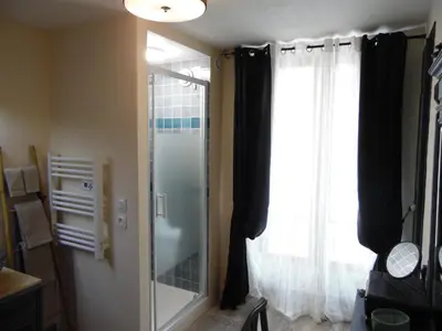 a glass shower in a room with a window at Chez Jérôme, au pied de la cité médiévale in Carcassonne