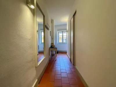 a hallway with a tile floor and a mirror at L'appartement des boulangers in Carcassonne