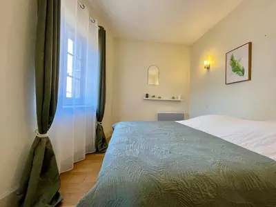 a bedroom with a large bed and a window at L'appartement des boulangers in Carcassonne