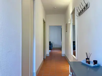 a corridor of a hallway with a tile floor at L'appartement des boulangers in Carcassonne