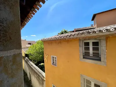 a view of a yellow building with a window at L'appartement des boulangers in Carcassonne