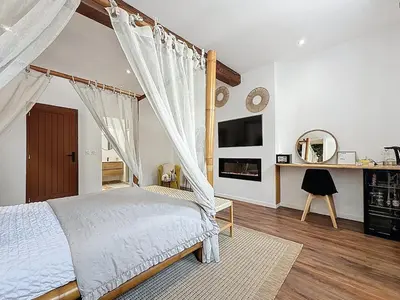 a bedroom with a four poster bed and a window at Cottages Occitans in Villepinte