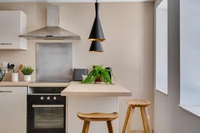 a kitchen with a counter and two stools at La Porte de la Cité, Maison Historique Vue Château in Carcassonne
