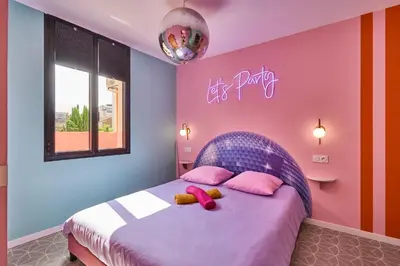 a bedroom with a bed with pink and purple walls at La Villa Orange - DISCO - proche cité médiévale et centre ville à pied in Carcassonne