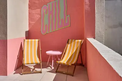 two yellow chairs and a table in front of a wall at La Villa Orange - DISCO - proche cité médiévale et centre ville à pied in Carcassonne