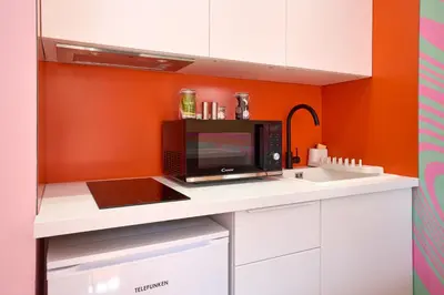 a microwave sitting on a counter in a kitchen at La Villa Orange - DISCO - proche cité médiévale et centre ville à pied in Carcassonne
