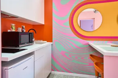 a kitchen with a colorful wall with a mirror at La Villa Orange - DISCO - proche cité médiévale et centre ville à pied in Carcassonne