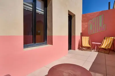 a patio with two chairs and a building at La Villa Orange - DISCO - proche cité médiévale et centre ville à pied in Carcassonne