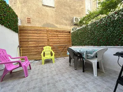 a patio with two chairs and a table and chairs at Le Montille - Appartement face au Port - Climatisation et Wifi in Port-la-Nouvelle