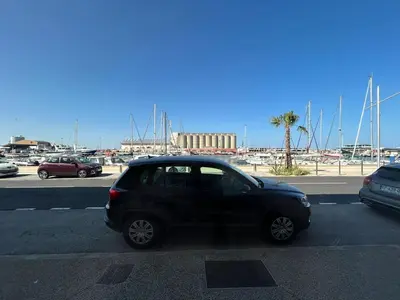 a black car is parked in a parking lot at Le Montille - Appartement face au Port - Climatisation et Wifi in Port-la-Nouvelle