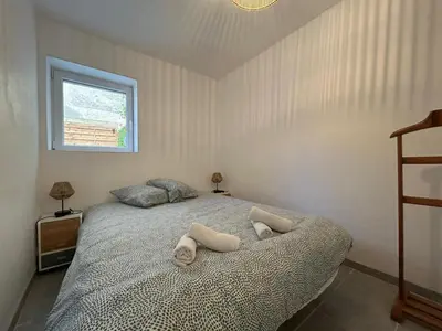 a bedroom with a bed with two towels on it at Le Montille - Appartement face au Port - Climatisation et Wifi in Port-la-Nouvelle