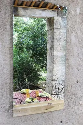 a mirror on the side of a stone building at Villa MAGRI 3 bedrooms in Cuxac-dʼAude