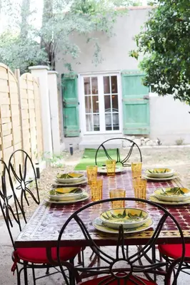 a table with chairs and plates of food on it at Villa MAGRI 3 bedrooms in Cuxac-dʼAude