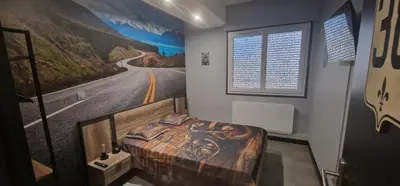 a room with a bed with a painting of a road at Relais Motards de Portel in Portel-des-Corbières