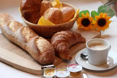 a tray of bread and croissants and a cup of coffee at Relais Motards de Portel in Portel-des-Corbières