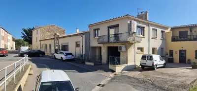a street with cars parked in front of buildings at Relais Motards de Portel in Portel-des-Corbières
