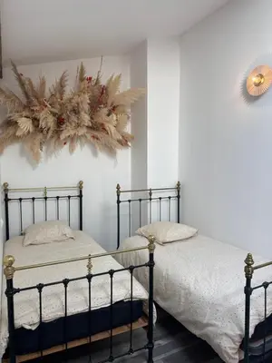two beds in a bedroom with areath on the wall at Domaine Rams in Villegailhenc