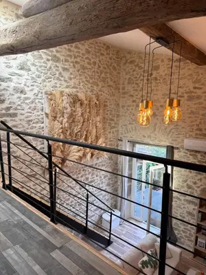 a room with a stone wall and two lights at Domaine Rams in Villegailhenc