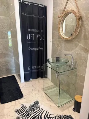 a bathroom with a glass sink and a shower at Domaine Rams in Villegailhenc