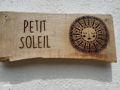 a wooden sign with the words petit solar on a wall at Petit Soleil in Quillan