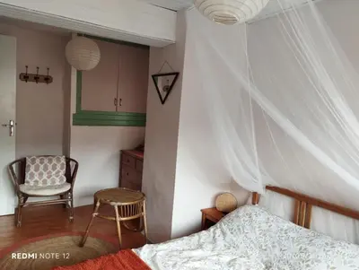 a bedroom with a bed and a chair at Petit Soleil in Quillan