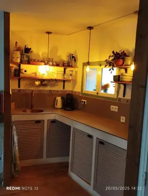 a kitchen with a counter with a sink and a window at Petit Soleil in Quillan