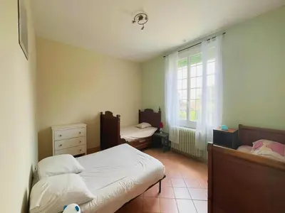 a bedroom with two beds and a window at Villa in St Denis with Pool & Pyrenees View in Saint-Denis