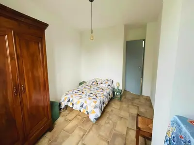 a bedroom with a bed and a wooden floor at Villa in St Denis with Pool & Pyrenees View in Saint-Denis