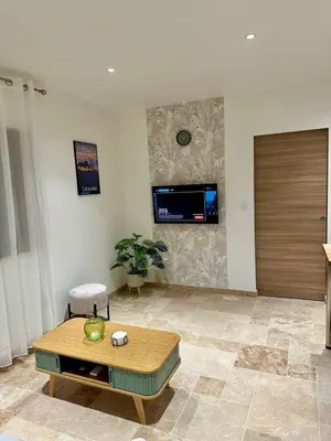 a living room with a table and a tv on the wall at L'étoile de Preixan in Preixan