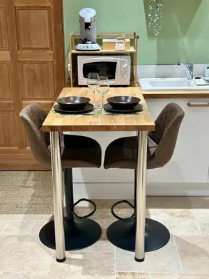 a table with two wine glasses and a microwave at L'étoile de Preixan in Preixan