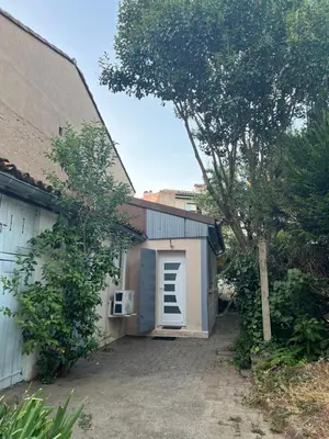 a garage with a door on the side of a building at Maisonnette Proche Gare & Centre l Jardin l Clim in Castres