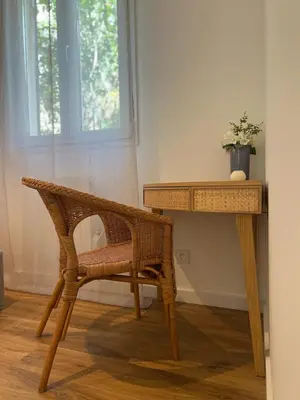 a wicker chair sitting next to a wooden desk at Maisonnette Proche Gare & Centre l Jardin l Clim in Castres
