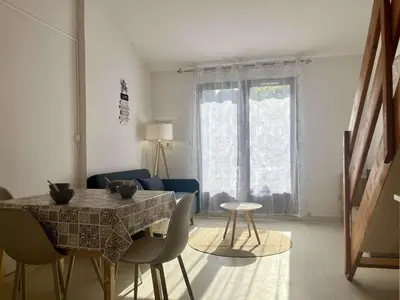 a living room with a table and chairs and a couch at Proche plage du Grazel, Pavillon avec piscine - GN530-008 in Gruissan