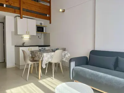 a living room with a blue couch and a table and chairs at Proche plage du Grazel, Pavillon avec piscine - GN530-008 in Gruissan