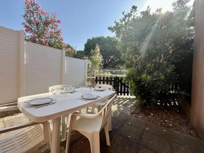 a white table and chairs on a patio at Proche plage du Grazel, Pavillon avec piscine - GN530-008 in Gruissan