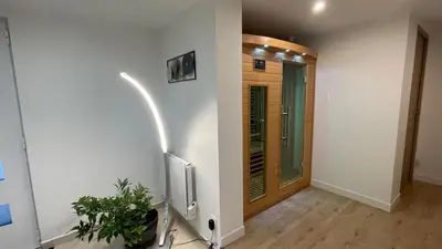 a hallway with white walls and a door with a plant at LE HAVRE D'ATHENA - Grand appart, jardin privé, abri vélos & accès rapide A61 in Castelnaudary